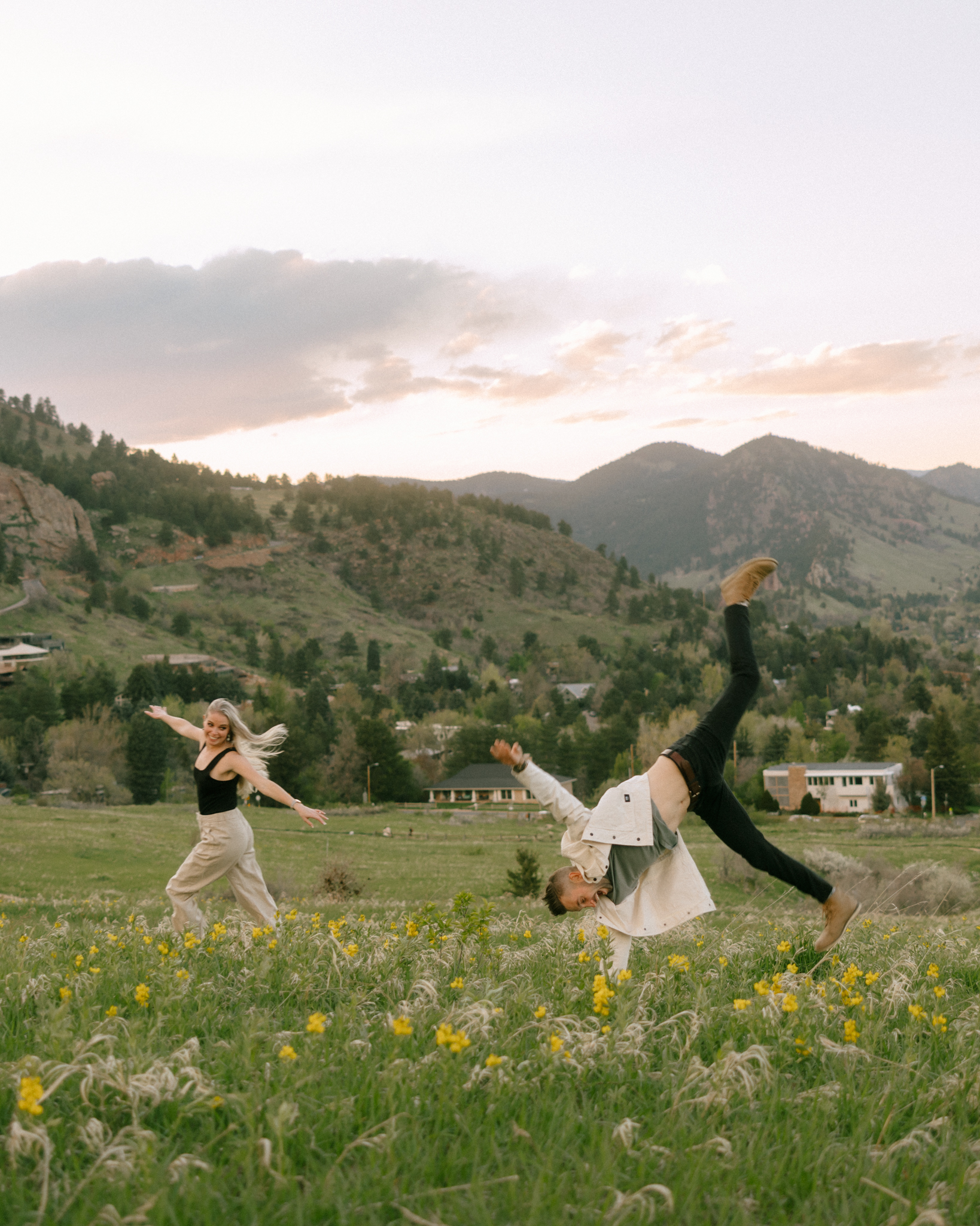 couple doing a cartwheel in a field in the mountains of colorado